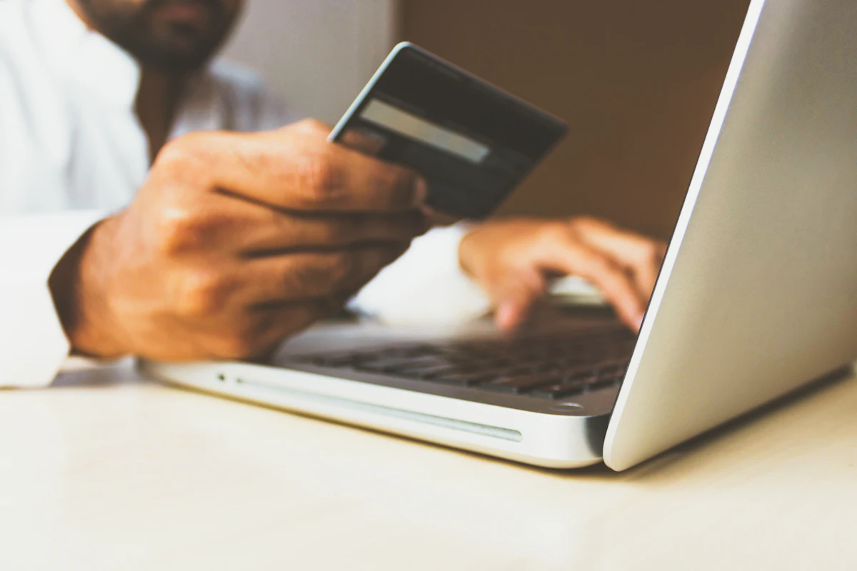 A person completing a card payment on a laptop during an online checkout.