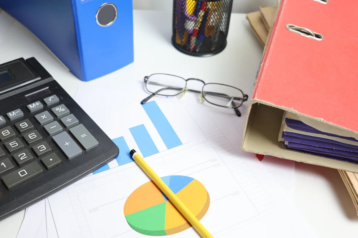 A finance team member using a calculator and reviewing financial documents while preparing a Gift Aid claim.